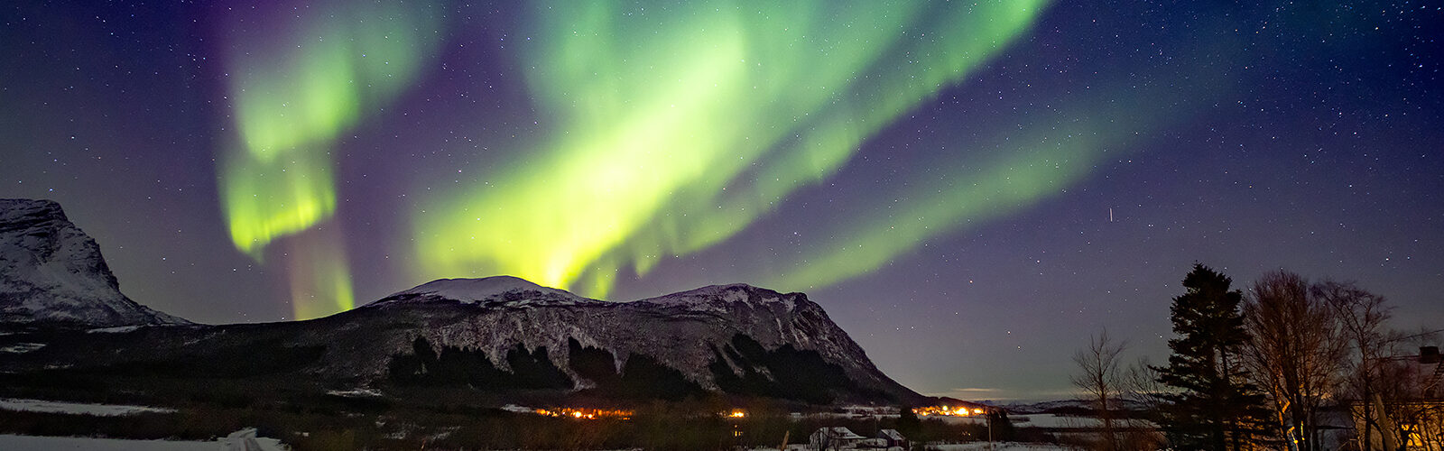 Über Steigen tanzen die Nordlichter und verwandeln den arktischen Himmel in pure Magie.